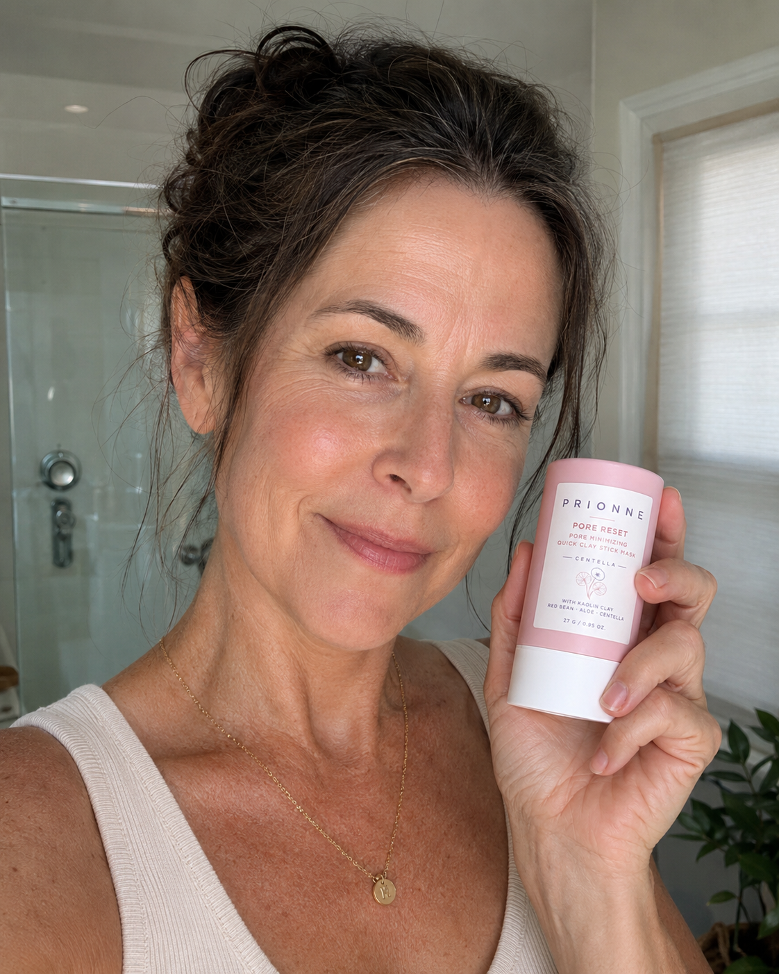 Mature female customer holding Prionne in a bathroom